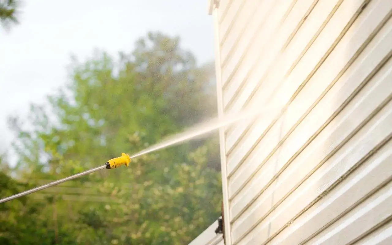 Pressure washing walls to remove dirt and old paint